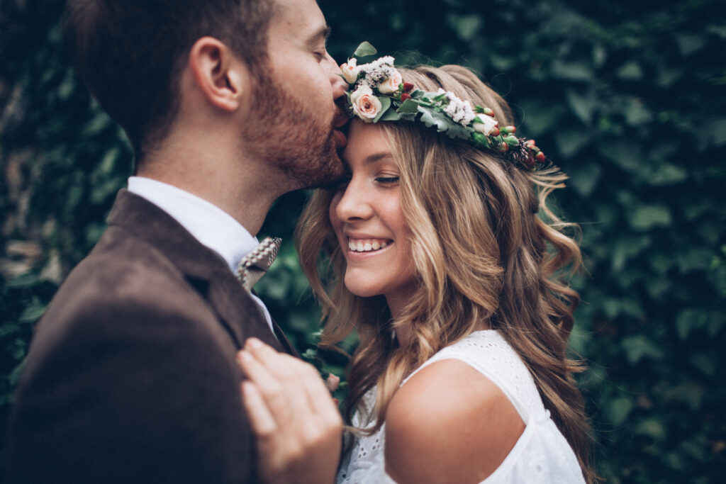 Smiling couple with heads close together on fall wedding day, looking radiant after beauty treatments in Sarasota, FL