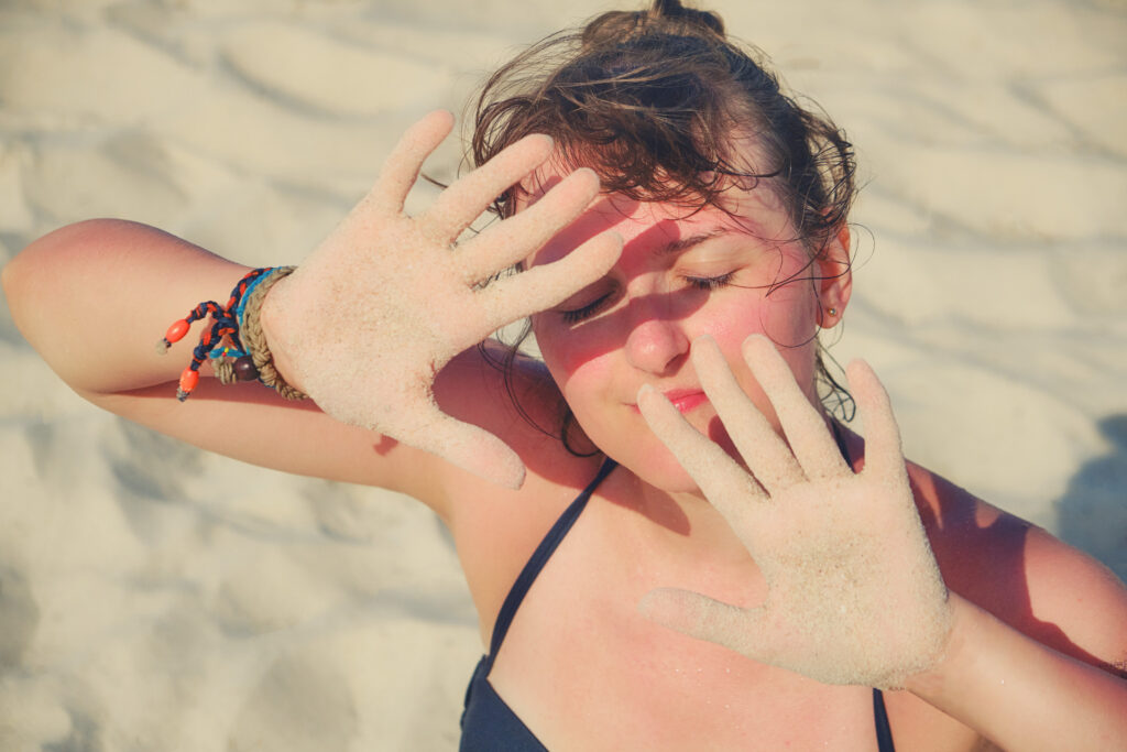 A woman holding up her hands to block the sun