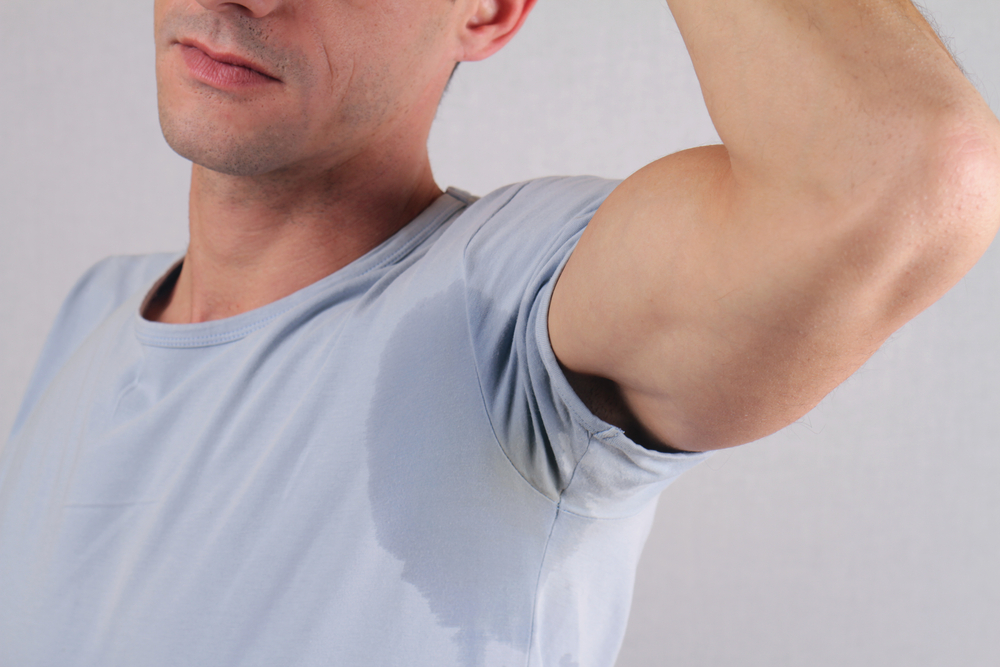A close-up shot of a man's armpit with a sweat stain from hyperhidrosis